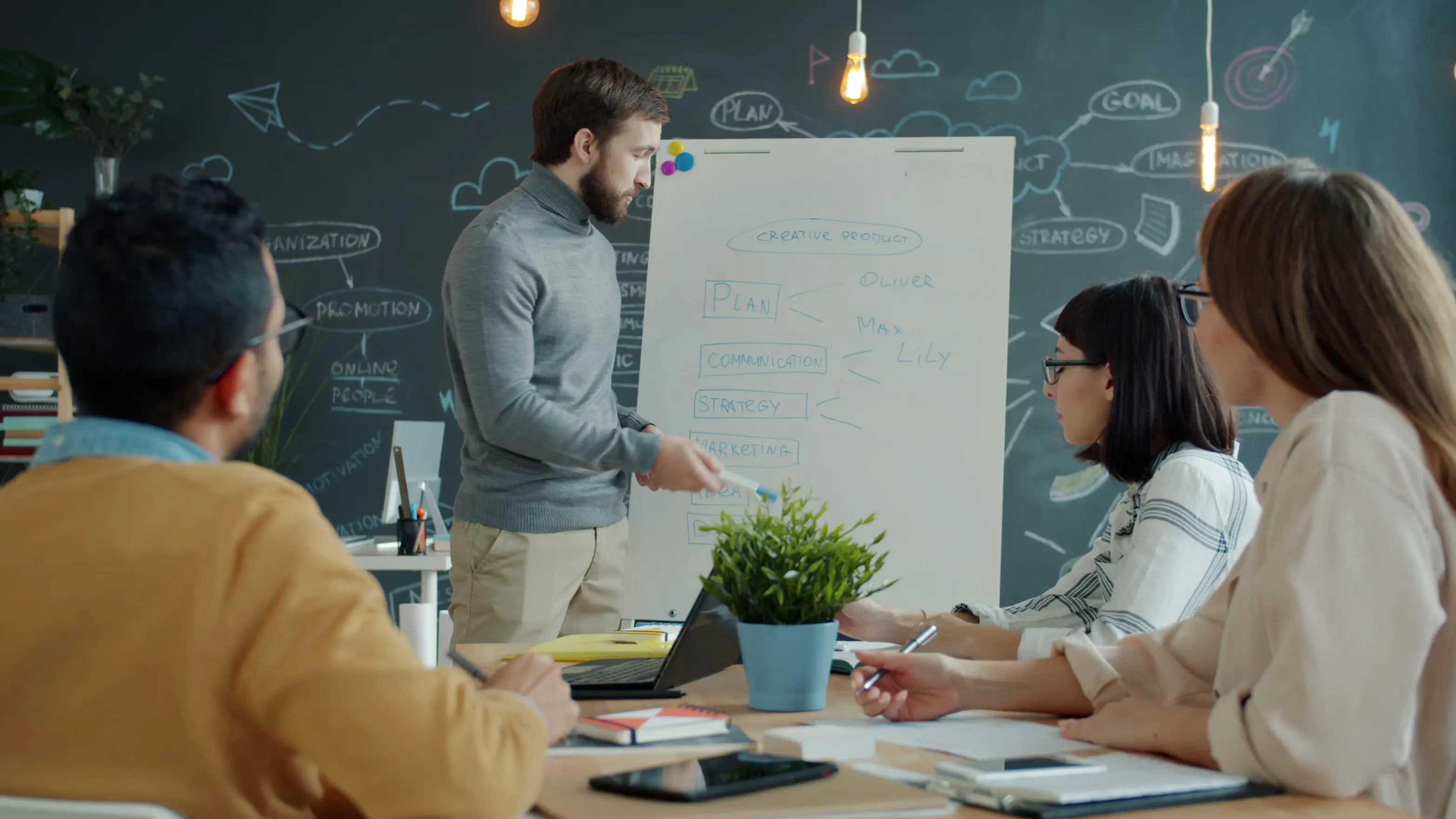 Office worker is making presentation to colleagues talking writing on whiteboard discussing marketing strategy. People and business discussions concept.